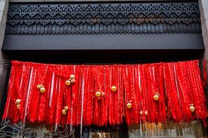 A beautifully designed store front that is adorned and decorated for the festive Christmas season, featuring lovely red ribbons and shiny gold ornaments that enhance its charm photo