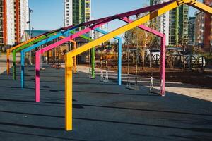 A vibrant and colorful structure situated in a lovely park area, complemented by buildings in the background that enhance the urban landscape and environment surrounding it photo