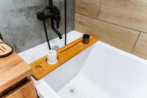 The bathroom features a stunning bathtub and a beautifully crafted wooden tray that enhance elegance and functionality, making the space unforgettable and visually appealing to visitors photo