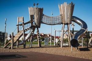 This playground is beautifully designed, showcasing a thrilling slide and an exhilarating rope bridge, allowing children to immerse themselves in enjoyable playtime adventures photo