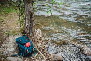 Pack your backpack and first aid kit for a day by the river in nature. Enjoy the scenic landscape, explore the wilderness, and stay safe while hiking and camping in the outdoors photo