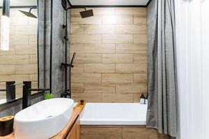 A welldesigned bathroom that includes essential features such as a sink, a tub for relaxation, a shower for convenience, and a mirror for personal grooming and reflection photo