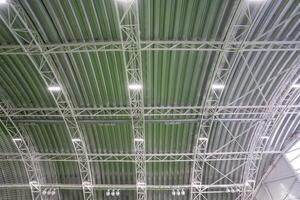 The ceiling of an extensive and spacious building that features a vibrant green roof, adorned with an array of bright lights that enhance its overall aesthetic and ambiance photo