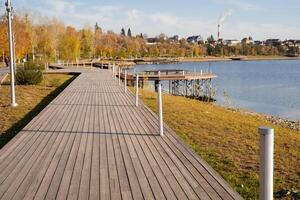 A scenic wooden walkway gracefully leads the viewer toward a tranquil body of water, inviting exploration and reflection amid the beauty of nature and its natural landscape photo