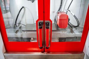A vividly striking red door that intriguingly conceals within it a complex and intricate machine that is embedded, hinting at the fascinating mechanical workings behind its vibrant exterior photo