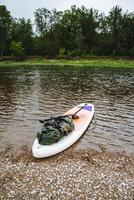 Equipment for a water trip is fixed on a SUP board, things are packed in a waterproof case, a dry bag for rafting on a SUP. photo