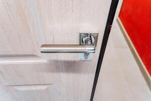 Silver handle of the front door to the house, top view of the handle of the holder, door to the apartment. photo