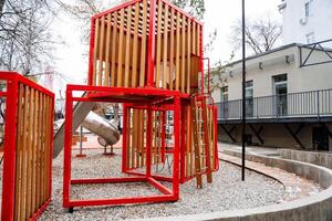 Nestled within a beautiful park, a charming wooden playground with an inviting slide and sturdy stairs offers a delightful space for children to play, engage, and explore the great outdoors photo