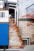There exists a brick wall that has various pipes protruding from its structure, which may be used for different functional purposes, enhancing the overall design of the building photo