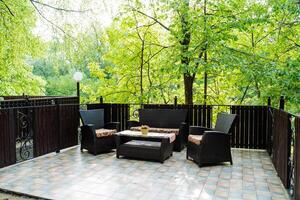 The patio is designed as a comfortable outdoor area with seating and a table, nestled among lush trees to offer a peaceful ambiance for unwinding and delighting in the surroundings photo