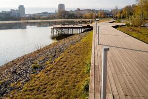 A wooden walkway leading to a lake with a dock in the background photo