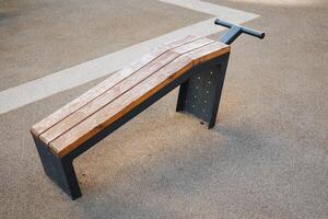 A sturdy wooden bench featuring a durable metal frame is sitting firmly on the ground, ready to provide seating for outdoor activities and gatherings in your backyard or park space photo
