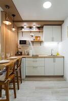 In a wellequipped kitchen, there is a lovely table surrounded by chairs, alongside a microwave for heating food, creating a functional and inviting space for meal preparation and gathering photo