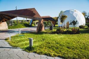 In the very center of the park, there is an impressive and large dome structure that captures the attention of all visitors who pass by or walk through the beautiful surroundings photo