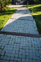 An Elegant Stone Pathway Featuring Beautiful Wooden Edges Surrounded by Lush Greenery, Set in a Peaceful and Serene Outdoor Environment photo