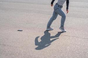 Person running on pavement after dropping a smartphone during the day photo