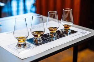 Enjoying whiskey tasting with four glasses and tasting notes on a table photo