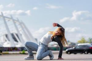 Young dancer performing a dynamic move in an urban outdoor setting photo