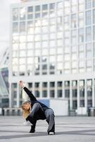Dancer performing dynamic move in urban setting during evening light photo