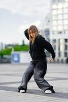 Young dancer practicing street style moves in an urban plaza setting photo