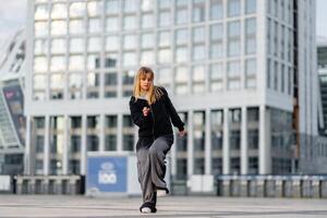 Young dancer performs street dance routine in urban setting during daytime photo