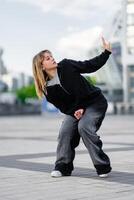 Dancer performing an expressive dance move in an urban setting photo