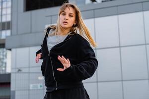 Young dancer performing a dynamic routine outdoors in an urban setting photo