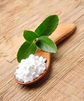 Stevia leaves. Stevia supplement in wooden spoon on wooden backgrounds photo