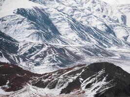 Texture of snow-capped mountains. Minimalist nature background of snowy mountainside. Misty mountain minimalism of snowbound mountain in low clouds. photo