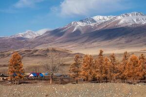 village in autumn, against the background of a snow-covered mountain photo