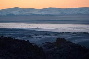 Highland river valley with morning fog on a background of snow covered mountains and glaciers with beautiful sunrise. in the steppe near the mountains during the autumn. Altai region. photo
