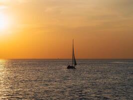 Yacht in calm at sunset. Minimalistic seascape. photo
