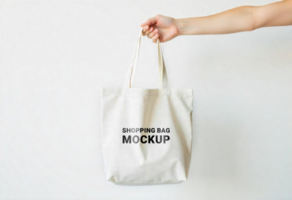 A hand is positioning a tote bag for a mockup display psd