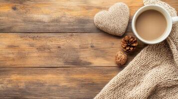 cozy scene with cup of coffee, knitted heart, pine cone, and warm scarf on rustic wooden table photo