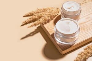 Face cream jars with natural dry grass photo