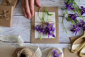 The scene depicts someone in the process of creating a floral arrangement, securing a bouquet of white flowers with a white lace ribbon. photo