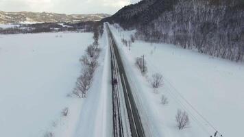 Drones camera show cars on traffic during snow. In background fields, roads video