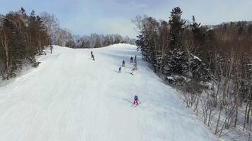 Drone view of a group of snowboarders descending the ski slope . video
