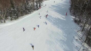 Drone view of a group of snowboarders descending the ski slope. video