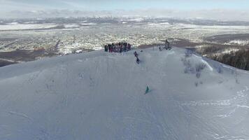 Drone view on a snowboarders on the top winter mountain. video