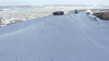 Drone view on a snowboarders on the top winter mountain video