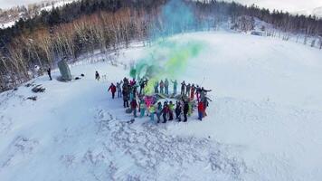 Drone view on a snowboarders on the top winter mountain with smoke bomb video