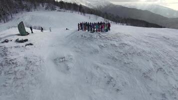 Drone view on a snowboarders on the top winter mountain video