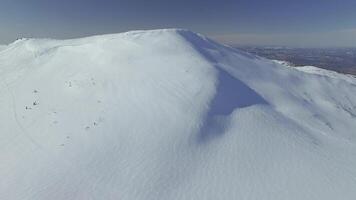Drone view on the snow mountain with traces of descents. video