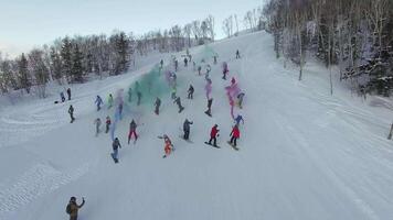 Drone view of a group of snowboarders descending the ski slope with smoke video