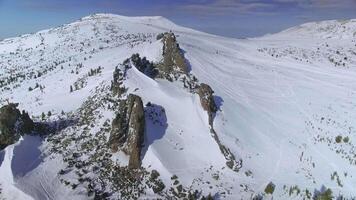 Drone view of the stone mountains under the snow near the snow-covered plateau video