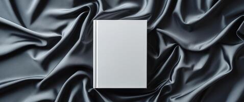 An empty white box on a dark fabric photo