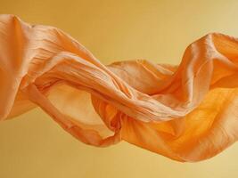 Flowing Orange Fabric on Bright Yellow Background Abstract Elegance in MotionFlowing Orange Fabric on Bright Yellow Background Abstract Elegance in Motion. photo