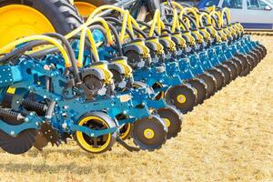 A fragment of a multi row seeder against the background of an agricultural field on a sunny day. photo