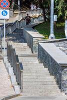 Comfortable stone staircase climbs up the slope in modern architecture of urban landscape design. photo